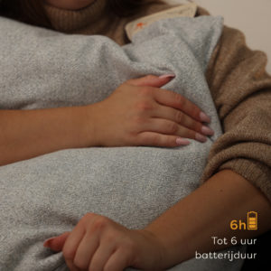 Vrouw die een warmtekussen vasthoudt.