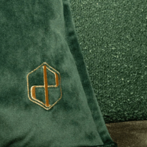 Gouden borduring op een groen warmtekussen